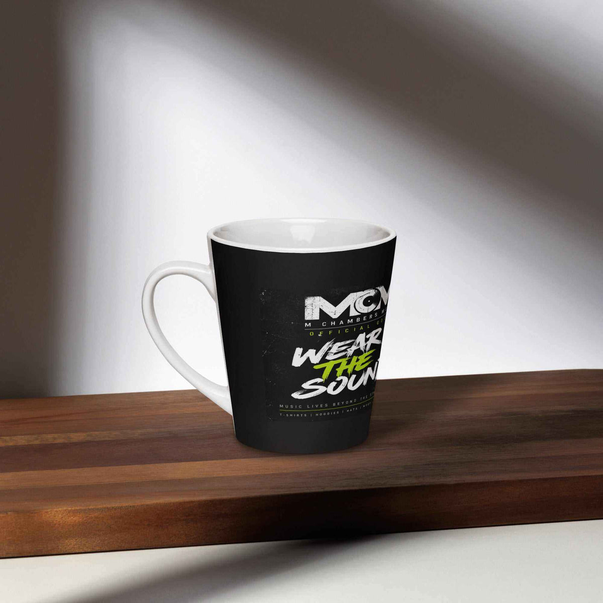 Ceramic latte mug with a black exterior, white rim and handle, featuring a bold Wear the Sound graphic